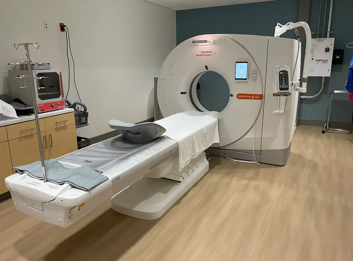 صورة فعلية لجهاز تصوير مقطعي CT وطاولة فحص في غرفة تصوير مقطعي بمستشفى