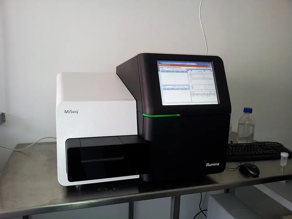 صورة فعلية لجهاز تسلسل جيني Illumina MiSeq على طاولة مختبر