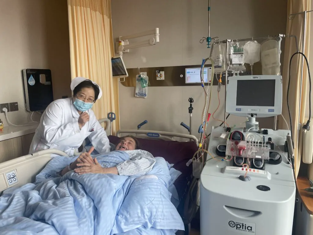 Amanda Harvey in a hospital bed with healthcare staff and cell collection equipment beside her