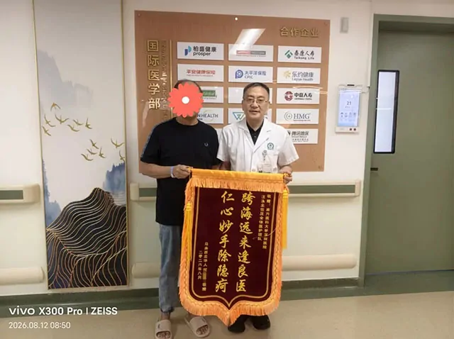 Mr HO presents a banner to a Shenzhen Hospital of Southern Medical University doctor; the patient's face is obscured in the original