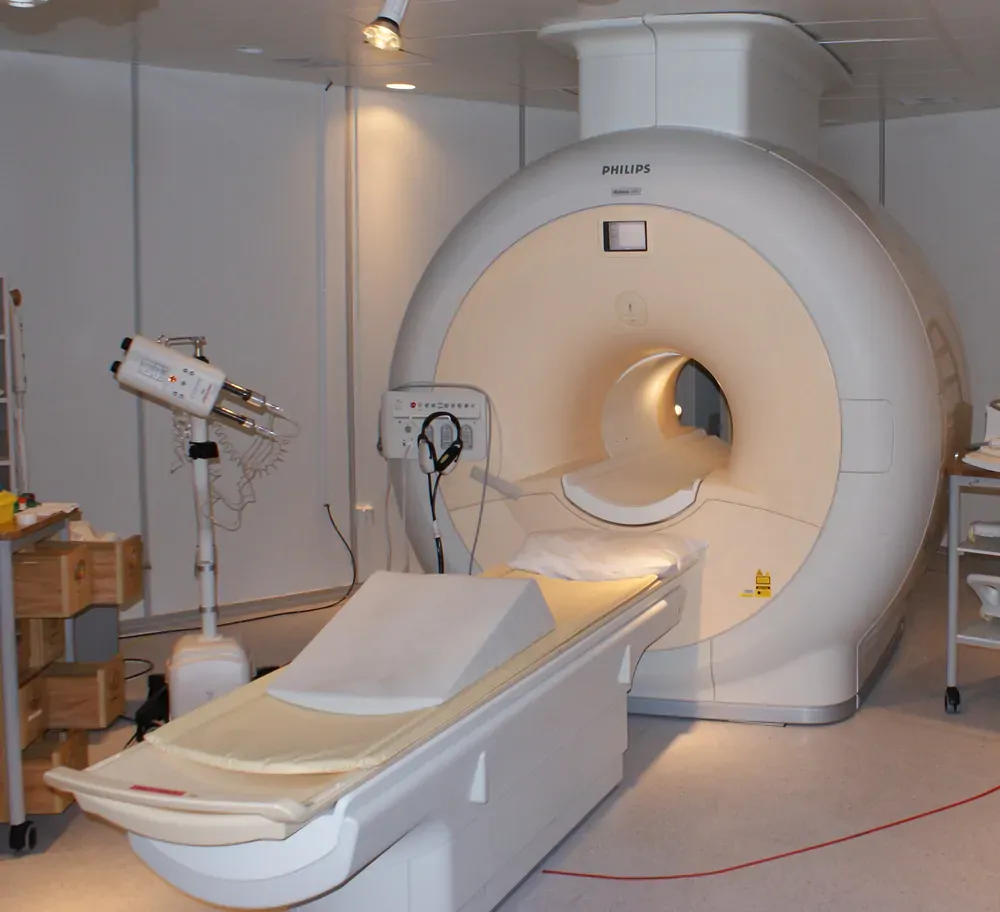 Photograph of an MRI scanner and examination table in a hospital room